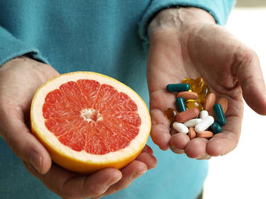 Doctor holding an orange and some vitamins