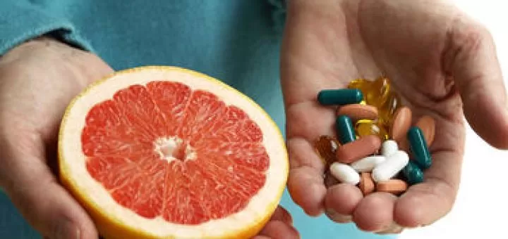 Doctor holding an orange and some vitamins